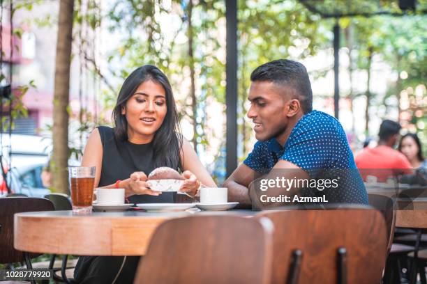 woman talking with male friend at sidewalk cafe - coffee shop couple stock pictures, royalty-free photos & images