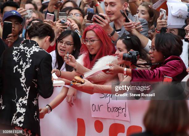 Fans hold out books, photos and a cheese burger hoping for a Timothée Chalamet autograph on the red carpet for the World Premiere of the movie...