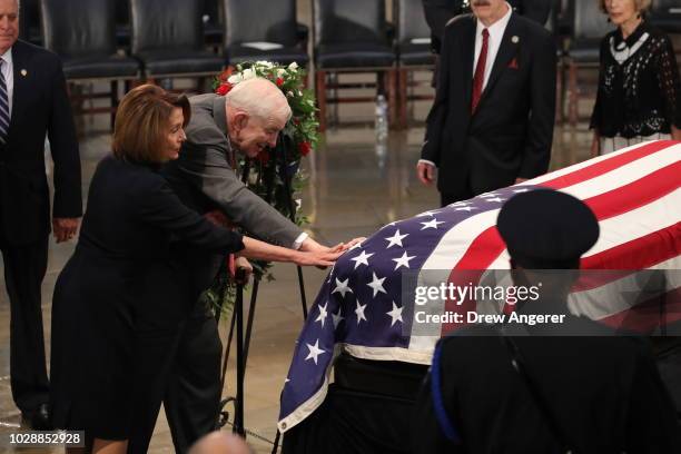 House Democratic Leader Nancy Pelosi and Sam Johnson, former congressman, and POW touches the casket during the ceremony honoring the late US Senator...