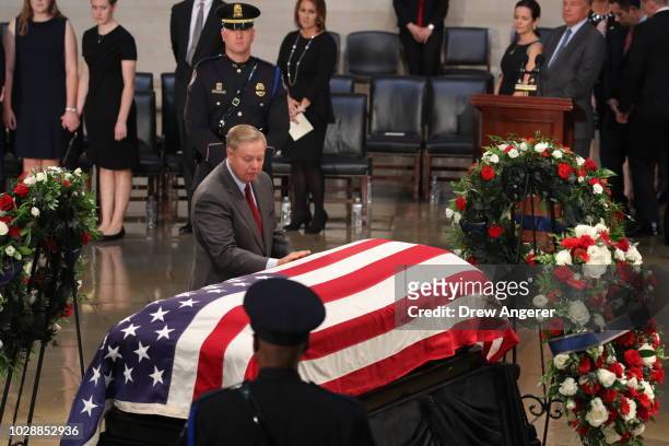 Sen. Lindsey Graham touches the casket during the ceremony honoring the late US Senator John McCain inside the Rotunda of the U.S. Capitol, August...