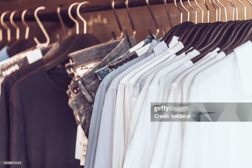 Shirts and jeans on hangers in clothing boutique