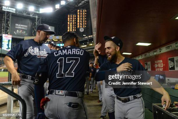 Johan Camargo of the Atlanta Braves celebrates in the dugout with Ender Inciarte after hitting a solo home run in the third inning of the MLB game...