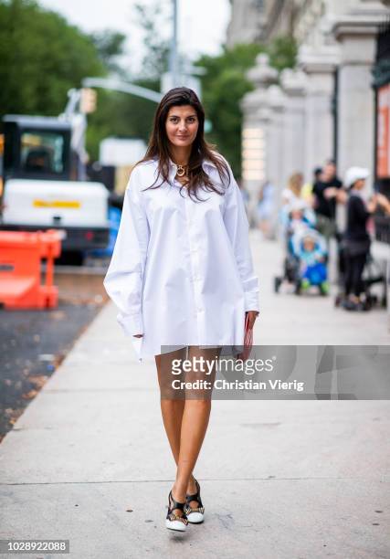 Giovanna Battaglia Engelbert wearing white dress, heels, red heart bag with NY print is seen outside Tory Burch during New York Fashion Week...