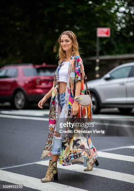 Sofia Sanchez De Betak wearing white cropped top, ripped denim jeans, ankle boots with snake print, Chloe bag with fringes, kimono is seen outside...