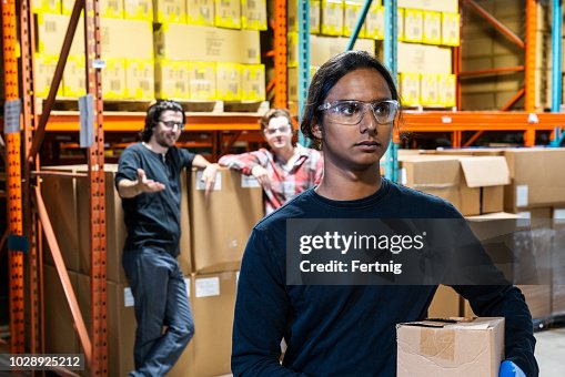 An industrial warehouse worker being the target of bullying An industrial warehouse worker being the target of bullying