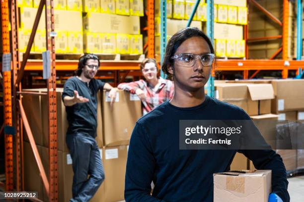 an industrial warehouse worker being the target of bullying - bullying workplace stock pictures, royalty-free photos & images