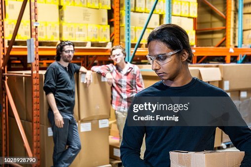 An industrial warehouse worker being the target of bullying An industrial warehouse worker being the target of bullying