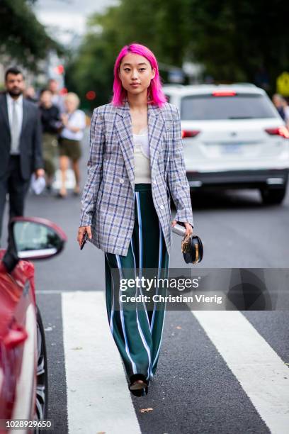 Margaret Zhang with pink hair wearing checked blazer, striped pants is seen outside Tory Burch during New York Fashion Week Spring/Summer 2019 on...