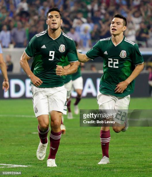 Raul Jimenez of Mexico celebrates with Hirving Lozano after scoring on a penalty kick against Uruguay in the firtst half during the International...