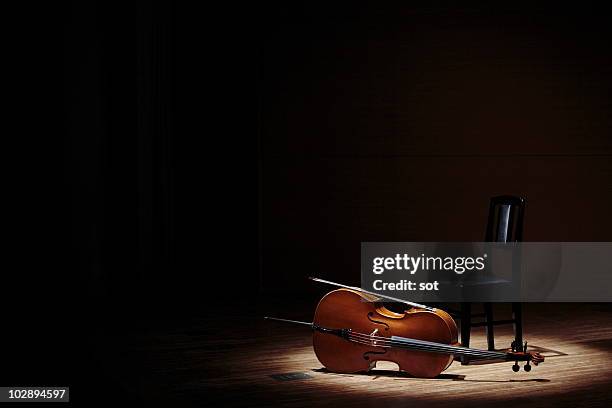 cello and chair on stage - bow musical equipment stockfoto's en -beelden