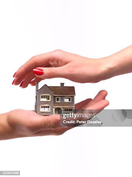 hands protecting house - home insurance stock pictures, royalty-free photos & images