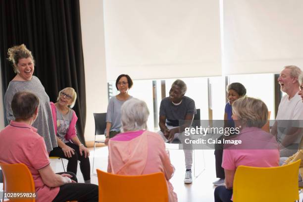 laughing active seniors meeting in circle in community center - elderly cognitive stimulation therapy stockfoto's en -beelden