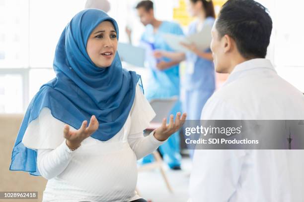 bezorgd zwangere vrouw praat met ob/gyn - pregnant muslim stockfoto's en -beelden