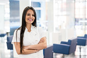 Cheerful manager of a hair salon looking at camera smiling with arms crossed