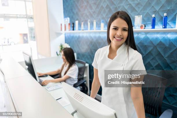 empresário de belo de um pé de salão de cabelo atrás da recepção sorrindo para a câmera - terapeuta de beleza - fotografias e filmes do acervo