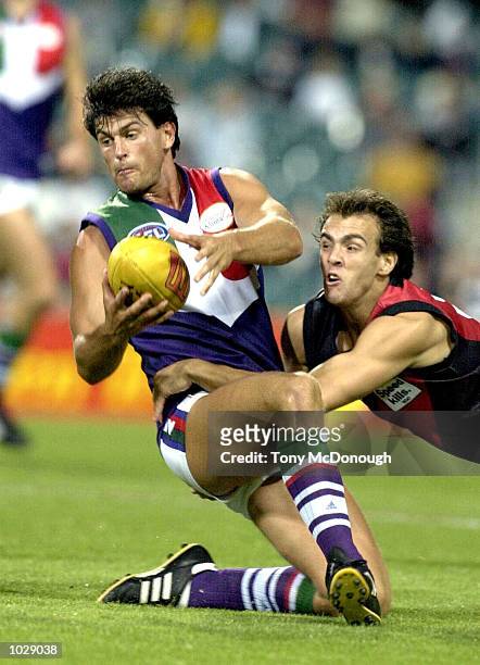Ashley Prescott for Fremantle is tackled by Adam Ramanauskas for Essendon in the match between the Fremantle Dockers and the Essendon Bombers during...