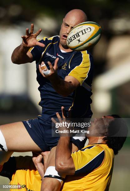 Nathan Sharpe is lifted by Salesi Ma'afu practising restarts during an Australian Wallabies training session at Coogee Oval on July 15, 2010 in...
