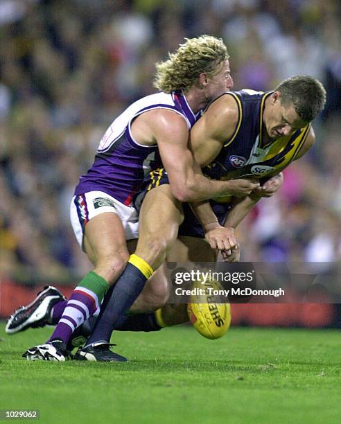 Shaun McManus for Fremantle lays the tackle on Glen Jakovich for West Coast in the match between the West Coast Eagles and the Fremantle Dockers...