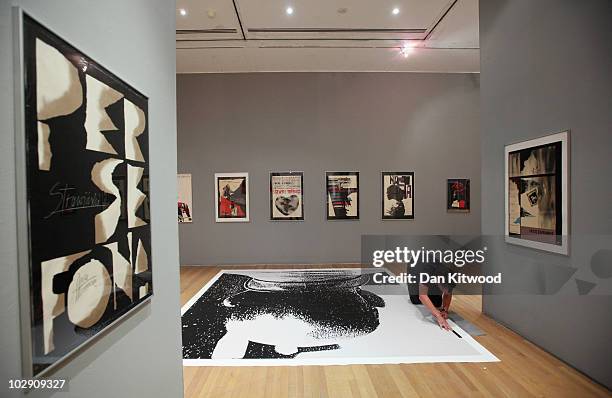 Curator puts the finishing touches to an exhibition by Polish artist and graphic designer Roman Cieslewicz at the Royal Academy of Arts on July 15,...