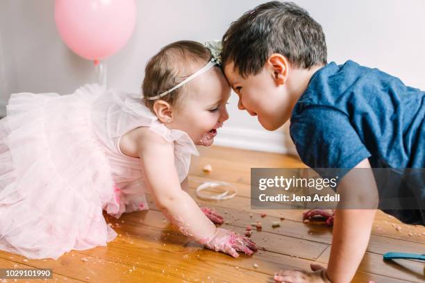 brother and sister, kids playing, boy and girl playing, siblings, brother and sister playing, big brother, little sister, family, sibling rivalry - lampoon first birthday event stock-fotos und bilder