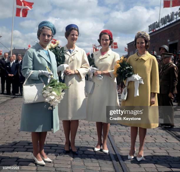 Queen Ingrid of Denmark holding a bouquet of flowers with her daughters, Princess Margrethe, Princess Benedikte, and Princess Anne-Marie, in Randers,...