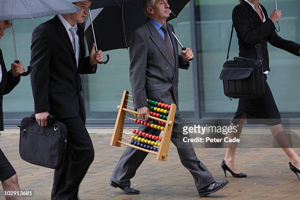 executives walking, one with abacus - abacus stockfoto's en -beelden