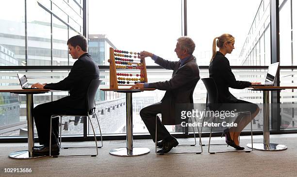 younger executives on laptops, older with abacus - abacus computer stock pictures, royalty-free photos & images