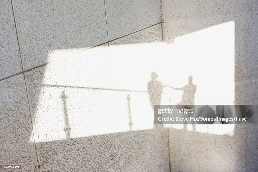 Shadows of businesspeople on a wall