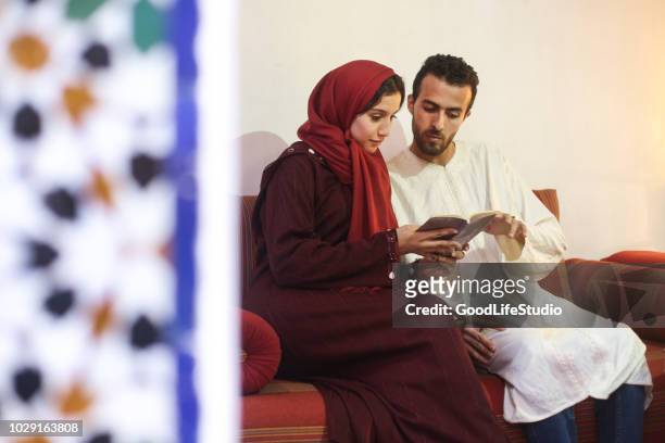 couple arabe lecture à la maison - maroc school photos et images de collection