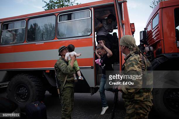 Foreign nationals fleeing violence are evacuated to the airport by a military convoy in front of the airport in Osh, Kyrgyzstan June 14, 2010....