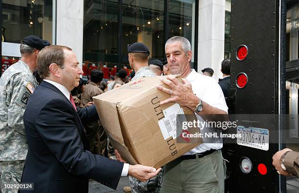 Commissioner Gary Bettman and retired Sgt. Joseph Bowser help pack a UPS truck during the Street Hockey Equipment Donation To Troops In Iraq event at...