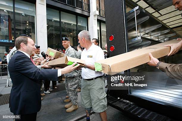 Commissioner Gary Bettman and retired Sgt. Joseph Bowser help pack a UPS truck during the Street Hockey Equipment Donation To Troops In Iraq event at...