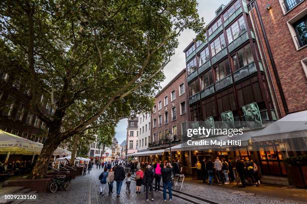 Visitors walk through the "Altstadt" old city, on August 27, 2018 in Dusseldorf, Germany narrow streets in old town home to cocktail bars, dance...