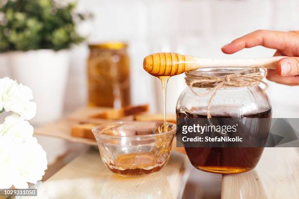 honing met honeycombs in een pot - honey stockfoto's en -beelden