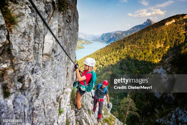 father shows daughter climbing in the alps - clambering imagens e fotografias de stock