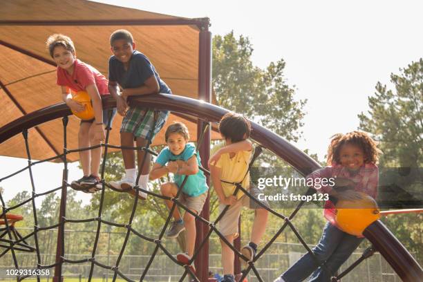 multi-ethnic group of school children playing on school playground. - jungle gym stock pictures, royalty-free photos & images