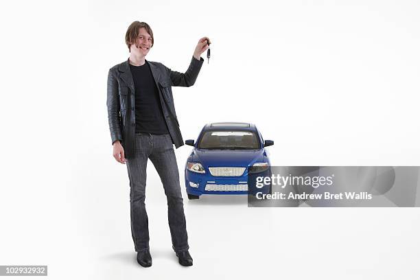 man hlding a car key in front of a toy car - auto stehend stock-fotos und bilder