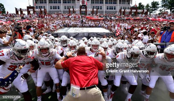 Head coach Dave Doeren and the North Carolina State Wolfpack take the field for their game against the Georgia State Panthers at Carter-Finley...