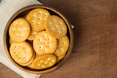 Round salted cracker cookies in wooden bowl putting on linen and wooden background