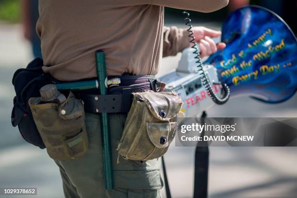 Pro-Trump street preacher carries a weapon as he taunts people waiting to enter the Anaheim Convention Center where former President Barack Obama is...