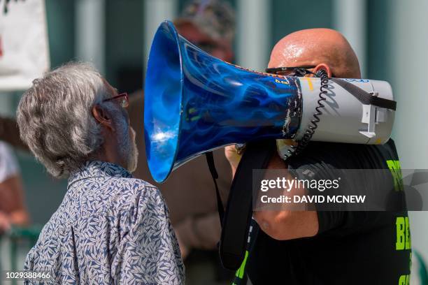 Pro-Trump street preacher aims his megaphone at a man who confronts him as he taunts people entering the Anaheim Convention Center where former...