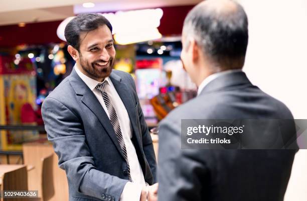 unternehmer-handshake im café - two executive man coffee shop stock-fotos und bilder