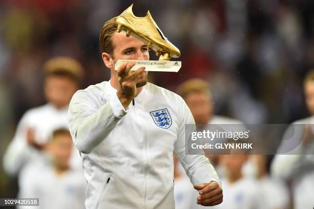 England's striker Harry Kane is presented with his Golden Boot award for being the top goal-scorer at the 2018 World Cup in Russia ahead of the UEFA...