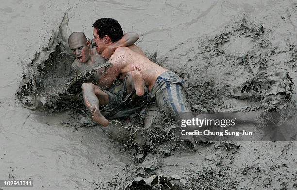 Participants wrestle in the mud during the 13th Annual Boryeong Mud Festival at Daecheon Beach on July 17, 2010 in Boryeong, South Korea. Now in its...