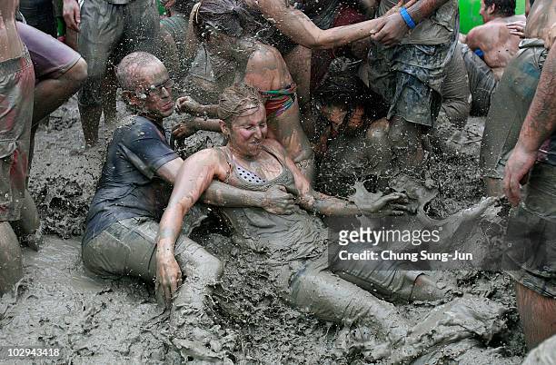 Participants wrestle in the mud during the 13th Annual Boryeong Mud Festival at Daecheon Beach on July 17, 2010 in Boryeong, South Korea. Now in its...