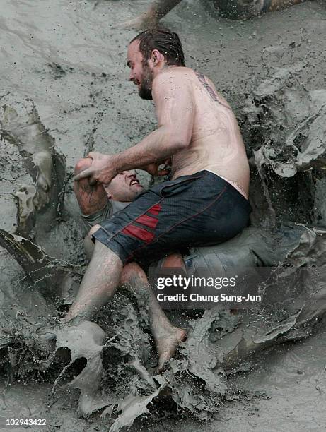 Participants wrestle in the mud during the 13th Annual Boryeong Mud Festival at Daecheon Beach on July 17, 2010 in Boryeong, South Korea. Now in its...