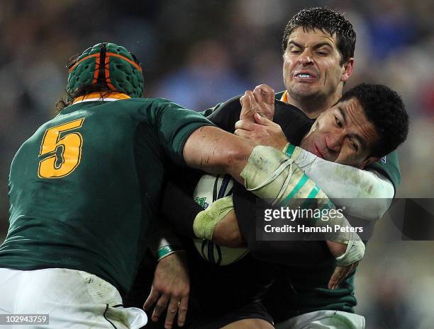 Mils Muliaina of the All Blacks is hit hard by Morne Steyn and Victor Matfield of the Springboks during the Tri-Nations match between the New Zealand...