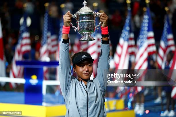 Naomi Osaka of Japan lifts her trophy after defeating Serena Williams of USA during the US Open 2018 women's final on September 8, 2018 in New York,...