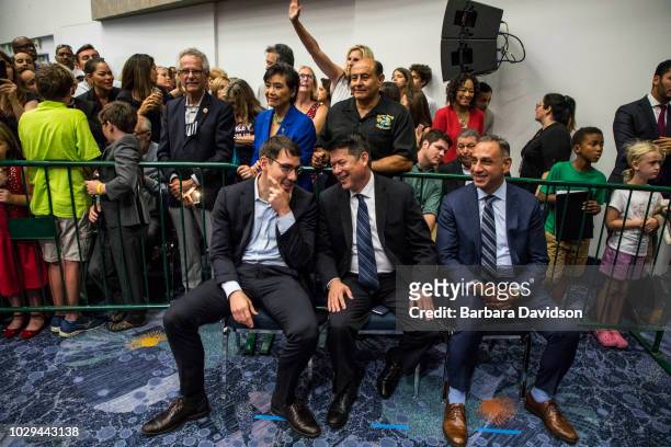 Josh Harder , TJ Cox , Gil Cisneros talk to each other before a Democratic Congressional Campaign Committee rally at the Anaheim Convention Center on...