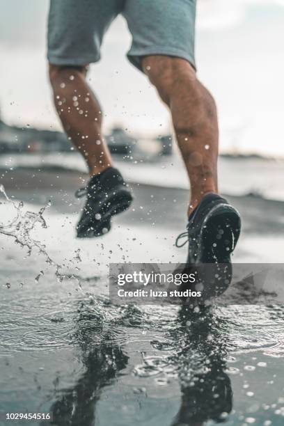 man running in the rain - feet jogging imagens e fotografias de stock